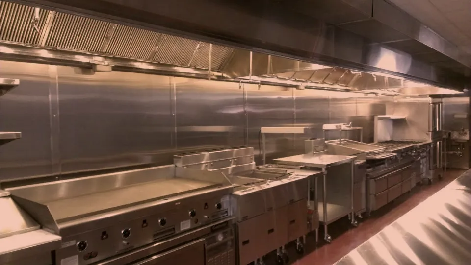 Full commercial cook line with stainless steel wall panels and exhaust hood, commercial kitchen fabrication by O'Donnell Metal Fab