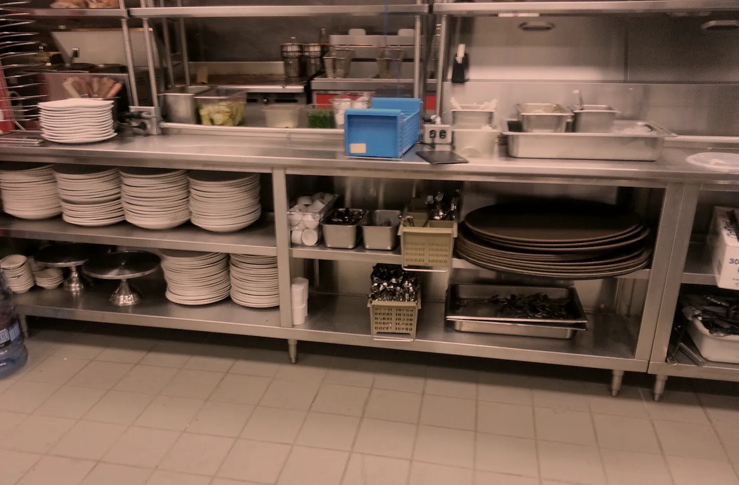 Stainless steel dish and plate counter with undershelves in a commercial kitchen, built by O'Donnell Metal Fab