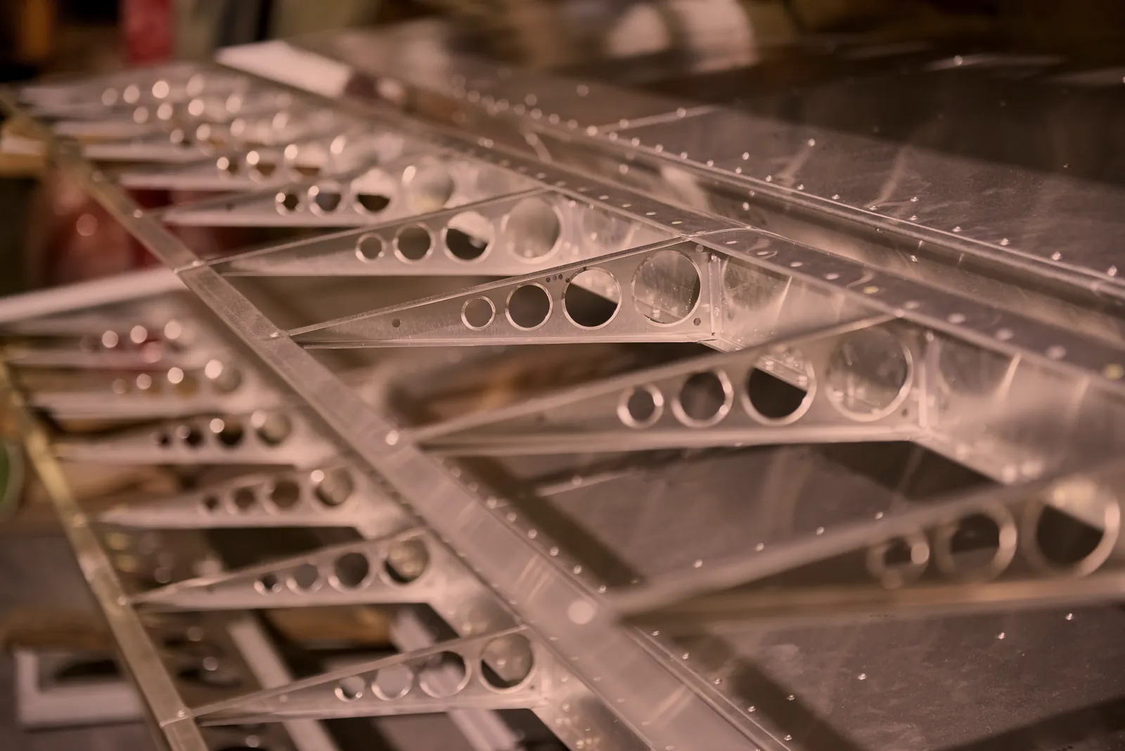 Lightened aluminum ribs with cut holes riveted to a skin panel, precision aluminum fabrication for aerospace and industrial parts