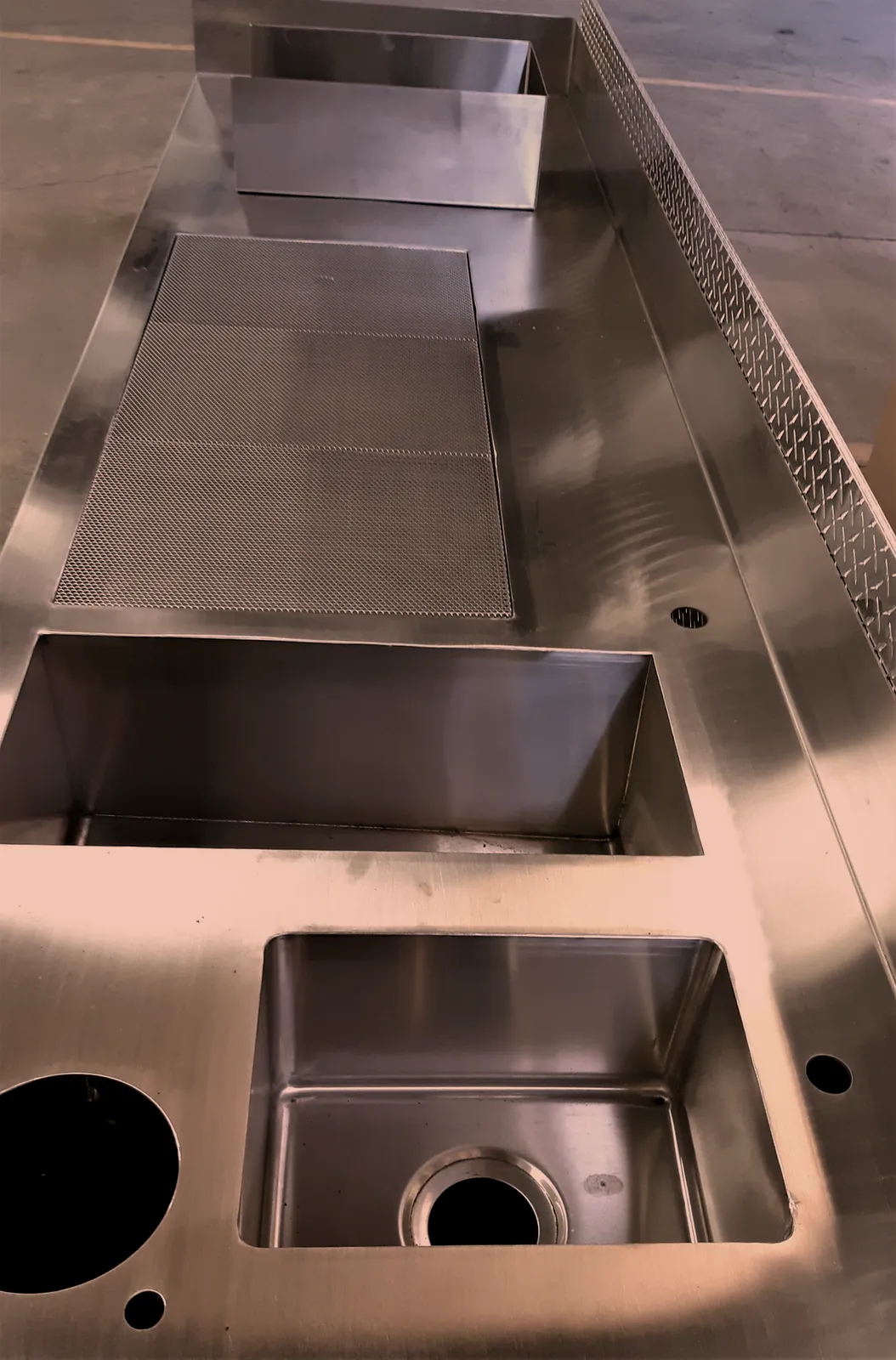 Custom stainless steel bar top with welded in sinks and a perforated drainboard, fabricated by O'Donnell Metal Fab in Norristown PA