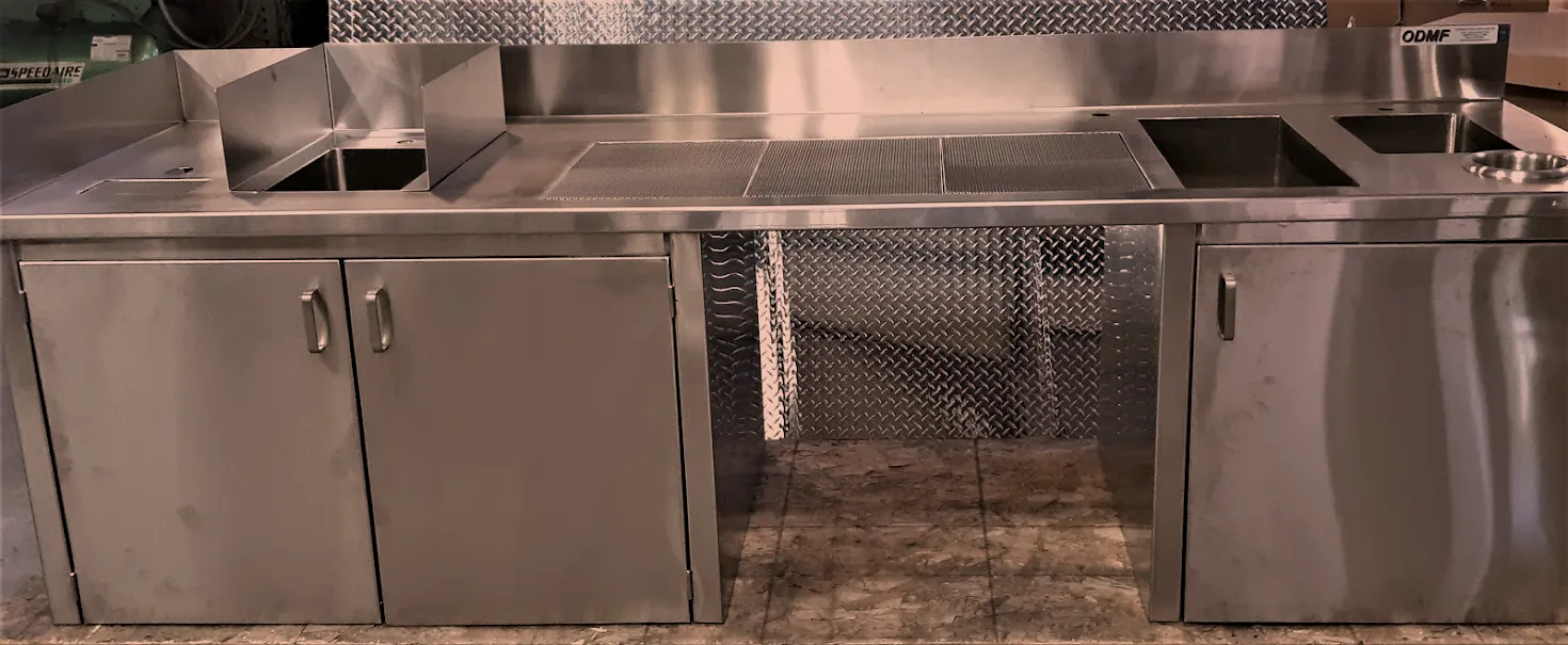 Custom stainless steel bar counter with base cabinets and drainboards carrying the ODMF tag, Norristown PA stainless fabrication