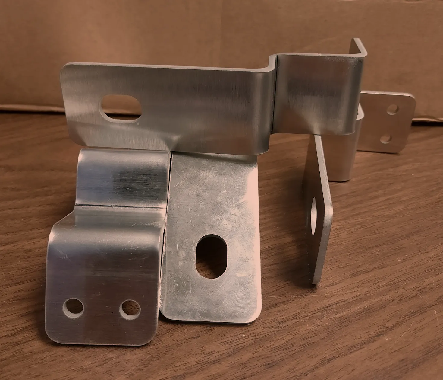 Close up of laser cut and press brake formed sheet metal brackets with holes and slots, O'Donnell Metal Fab Norristown PA